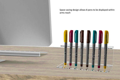 Pen and sharpie holder holds eight writing utensils on a desk with a monitor and verbiage and text